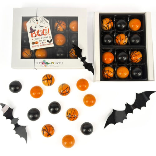 Assortment of white‑chocolate‑coated orange praline bonbons and black spiced pumpkin ganache bonbons created by Florian Poirot.