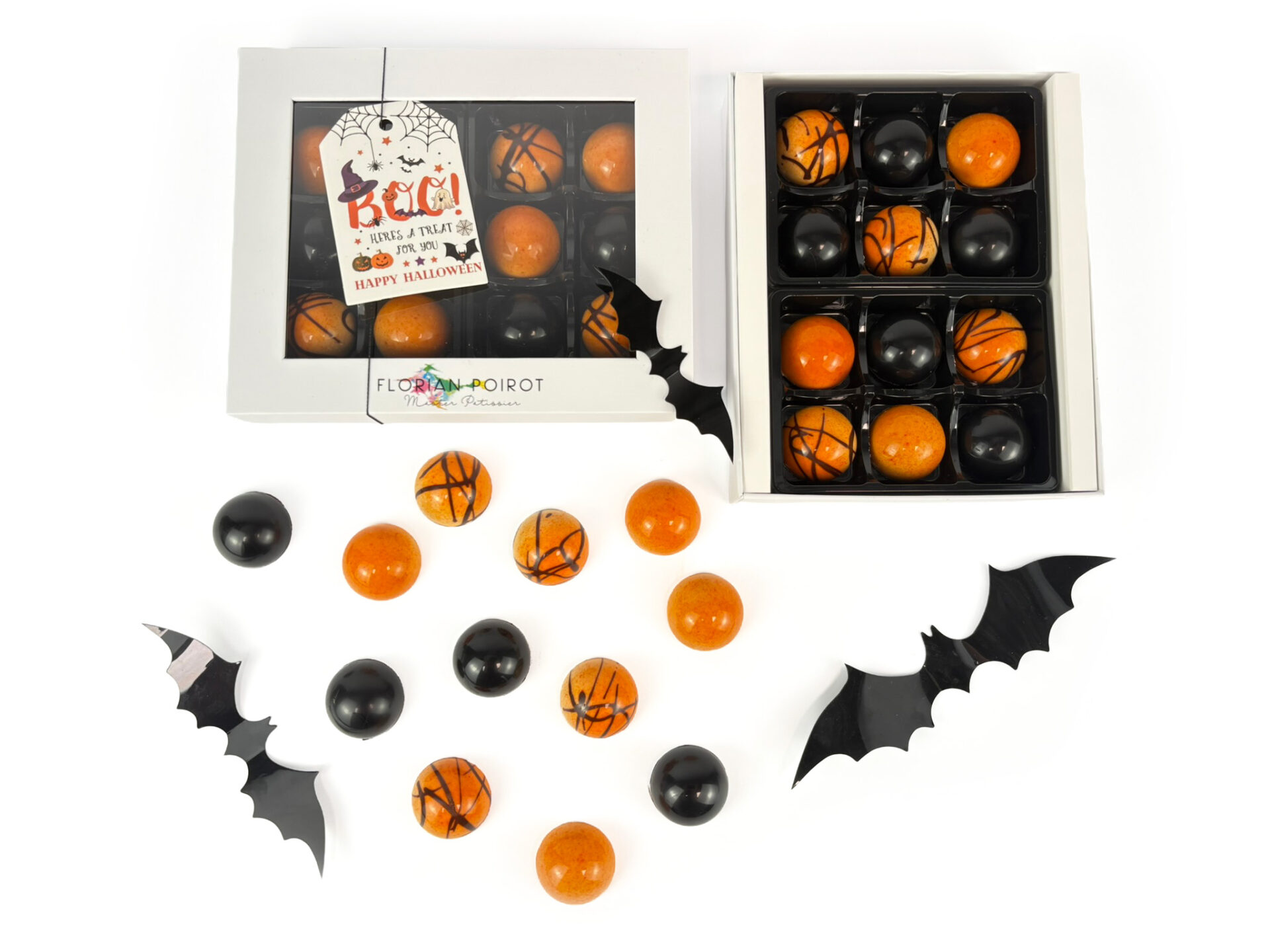 Assortment of white‑chocolate‑coated orange praline bonbons and black spiced pumpkin ganache bonbons created by Florian Poirot.